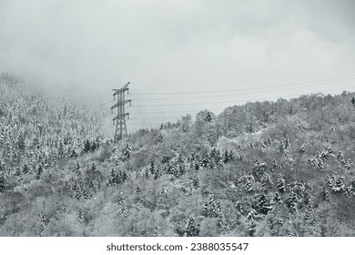 Power line in winter, big, high voltage pylon on minimalist, snowy mountain landscape - Powered by Shutterstock