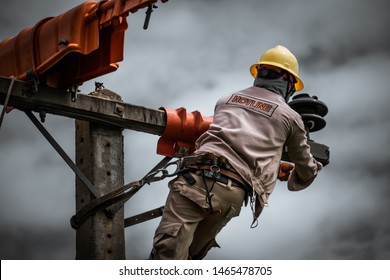 The power lineman is replacing the damaged insulator. That causes a power outage with protective equipment that is insulated and wearing personal protective equipment such as safety belt, helmet.