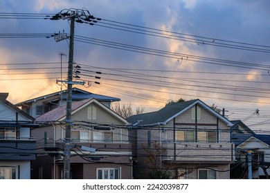 Power lines over suburban homes with storm clouds at sunrise - Powered by Shutterstock