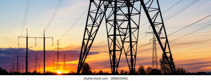 Power lines at the sunset header. Electricity distrubution end environment concept
