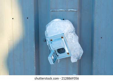 Power Outlet Covered In Winter Ice Barely Hanging On To Wall