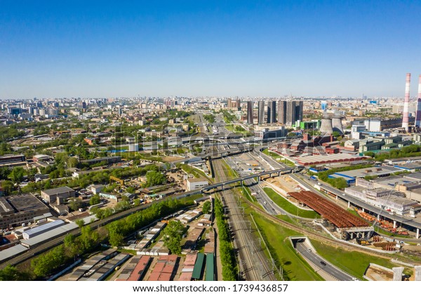 Power\
plant pipes and cooling towers in Moscow from above, automobile\
traffic and the old Ugreshskaya railway station in the Moscow\
industrial zone near the automobile ring\
highway.