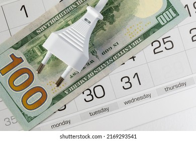 Power Plug Type C And Hundred US Dollars On Calendar. Concept Of Date Of Payment For Electricity, Tariff Increase