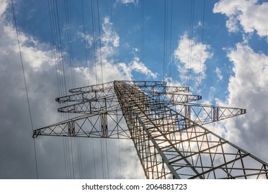 Power pole and power lines with blue sky and first thunderclouds in the background