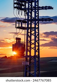 Power pole with transformer at sunset