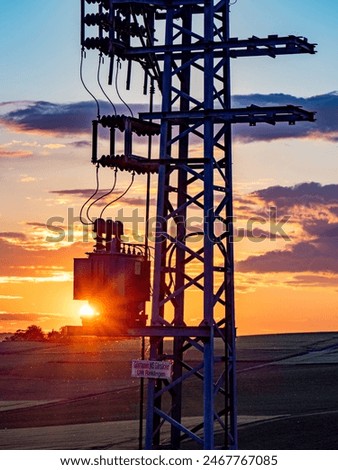 Power pole with transformer at sunset