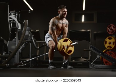 Power. Portrait of young muscular man training shirtless in gym indoors. Lifting barbell exercise. Relief body shape. Concept of health, sportive lifestyle, fitness, body care, diet, strength - Powered by Shutterstock