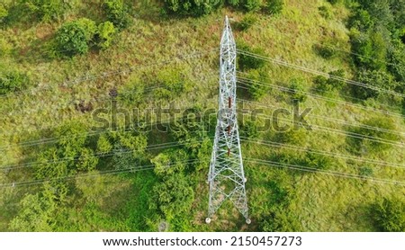 Power pylons and high voltage lines in a mountainous Areaagricultural landscape. High-voltage masts. Electricity transmission power lines. 4K, UHD, Cinematic, Aerial footage