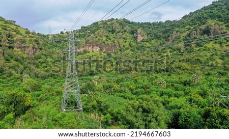 Power pylons and high voltage lines in a mountainous Areaagricultural landscape. High-voltage masts. Electricity transmission power lines. 4K, UHD, Cinematic, Aerial footage