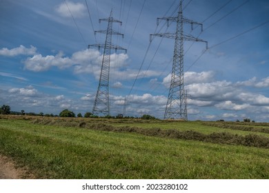 Power Pylons Of An Overhead Line And Cloudy Sky