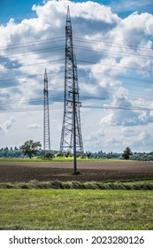 Power Pylons Of An Overhead Line And Cloudy Sky