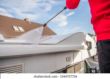 Power RV Roof Washing. Caucasian Men Pressure Washing His Camper Van Roof Elements.