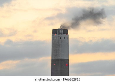 Power Station Industrial Chimney With Smoke At Sunset. Global Warming Pollution Emitting Industrial Greenhouse Gasses Whilst Generating Electricity.