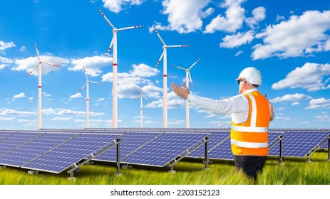 Power Station Worker. Green ECO Energy. Solar Panels And Windmills. Working Man Rejoices At Launch ECO Power Plant. Obtaining ECO Energy From Sun And Wind. Power Plant Worker With His Back To Camera