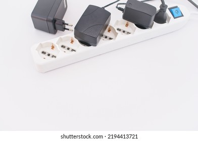 Power Strip And Electrical Cables With Chargers On A White Table With Copy Space