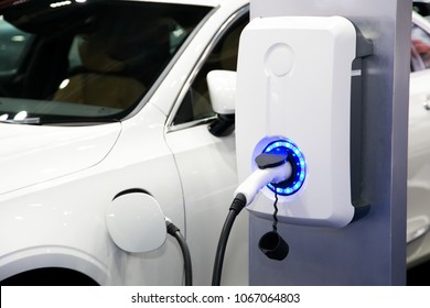 Power supply for electric car charging. Electric car charging station. Close up of the power supply plugged into an electric car being charged - Shutterstock ID 1067064803