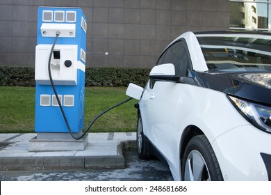 Power supply for electric car charging. Electric car charging station. Close up of the power supply plugged into an electric car being charged.