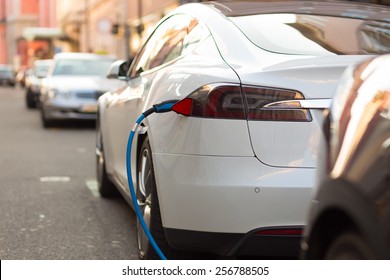 Power supply for electric car charging. Electric car charging station. Close up of the power supply plugged into an electric car being charged.