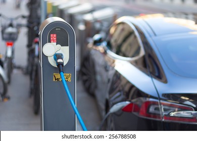 Power supply for electric car charging. Electric car charging station. Close up of the power supply plugged into an electric car being charged.