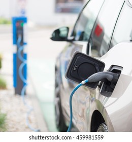 Power supply for electric car charging.  Electric car charging station. Close up of the power supply plugged into an electric car being charged. - Shutterstock ID 459981559