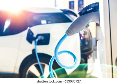 Power supply for electric car charging. Electric car charging station. Close up of the power supply plugged into an electric car being charged.