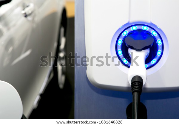 Power supply for electric car charging. Electric\
car charging station. Close up of the power supply plugged into an\
electric car being\
charged