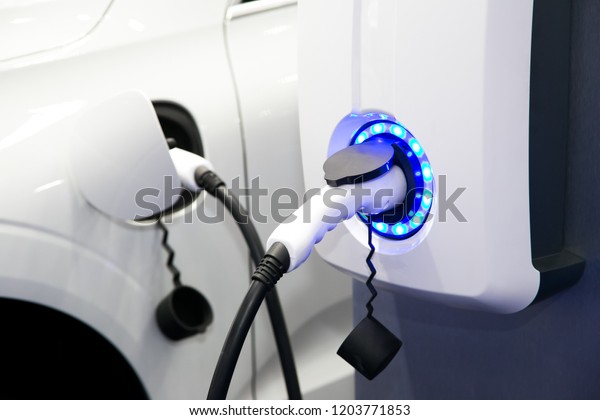 Power supply for electric car charging. Electric\
car charging station. Close up of the power supply plugged into an\
electric car being\
charged