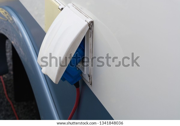 Power supply for electric car\
charging. Charging station for electric cars. Connecting a power\
supply, which is plugged into an electric car and\is\
charged.\