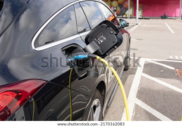 Power supply for electric car charging. Electric\
car charging station. Close up of the power supply plugged into an\
electric car being\
charged.