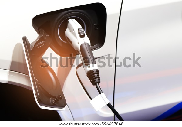 Power\
supply for electric car charging. Electric car charging station.\
Close up of the power supply plugged into an electric car being\
charged. car plugin hybrid.soft and selective\
focus