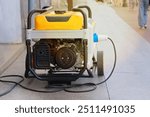 Power supply generator placed on street sidewalk. Outdoor diesel power generator. Small business use gasoline generators.