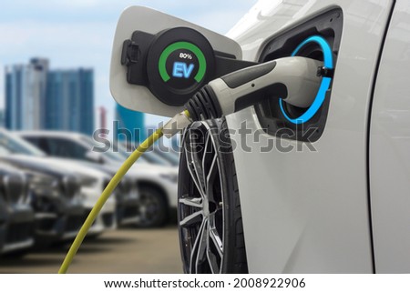 Power supply loading energy an electric car charging lithium battery on blurred city background.
