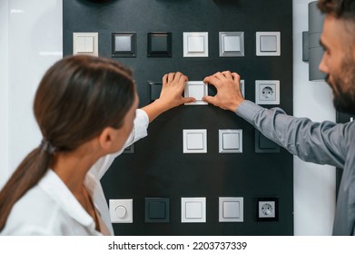 With power switches. Woman and man is in the store of goods for the home. - Powered by Shutterstock