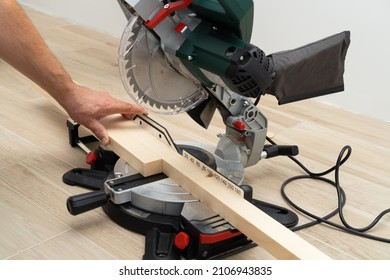 Power Tool Miter Saw In Hands Of A Handyman Sawing Wood Parts.