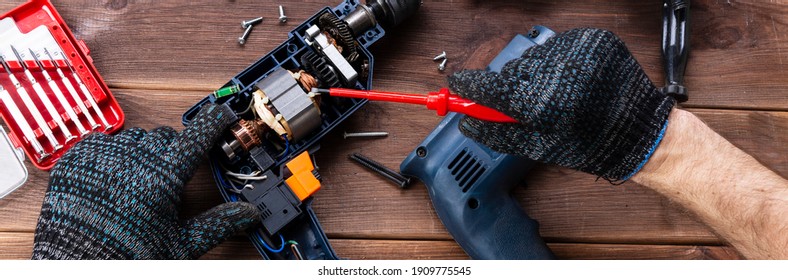 Power Tool Repair. Details Of Electrical Appliance And Repair Tools On A Wooden Table In A Repair Shop.