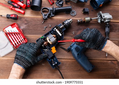 Power Tool Repair. Details Of Electrical Appliance And Repair Tools On A Wooden Table In A Repair Shop.