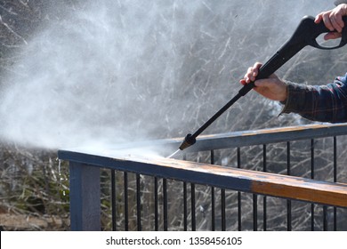 Power Washer  Being Used To Remove Loose Paint On A Deck Railing