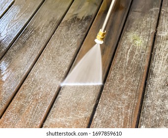 A Power Washer Washing A Deck