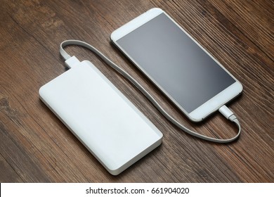 powerbank and cellphone on wooden table