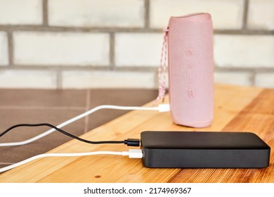 Powerbank charges portable speaker using usb. Close-up, selective focus