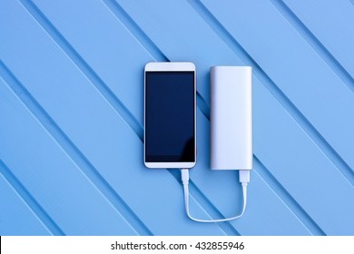 Powerbank Charging Smartphone - Outdoor, Blue Wooden Background