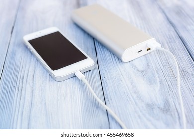 Powerbank Charging White Smartphone - Outdoor, Wooden Background