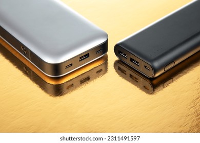 Powerbank portable on a golden background. Electronic devices for charging gadgets and smartphones - Shutterstock ID 2311491597