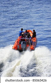 A powerboat heading out to sea at high speed leaving a white wake. Space for text on the water at top