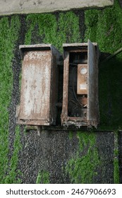 Powerbox behind a wall separating water and land, water leaks from the wall, on the electricity box