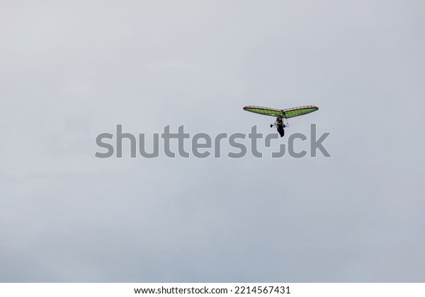 Powered hang glider flying in blue sky. Motorized\
hang glider, ultralight trike overhead view, copy space.  Extreme\
tourism concept