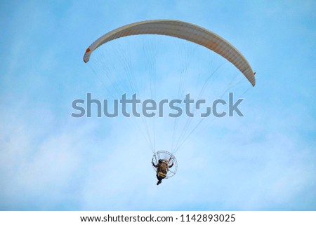 Powered Paragliding or Paramotoring (PPG) : human flying with motor on the back and parachute for travelling.