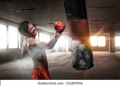 Powerful asian male boxer with punching bag for uppercut training