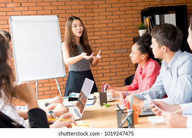 Powerful Asian Woman Leader Making A Presentation To Her Colleagues In Meeting Room