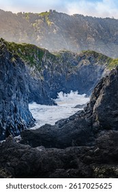 Powerful Atlantic waves collide with the dramatic volcanic rock formations along Sao Jorge Island rugged coastline. When calm, these basalt enclosures form natural swimming pools at Faja dos Cubres